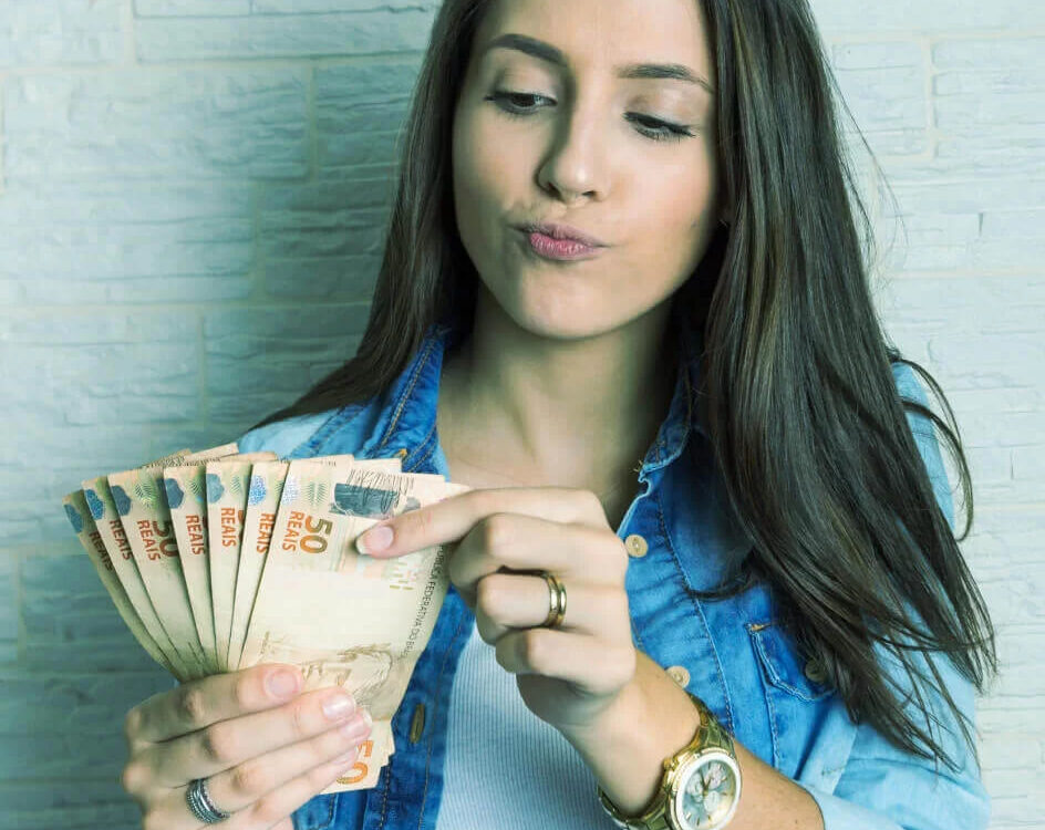 Mulher contando cédulas de dinheiro