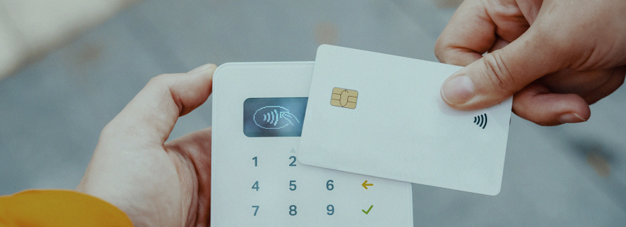 Uma pessoa fazendo pagamento com cartão de crédito usando aproximação numa máquina de cartões.